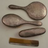 A hallmarked silver four piece dressing table set, comprising mirror, two brushes and a comb