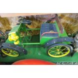 A vintage De Dion style pedal motor car, in John Deere colours, with swing pedals and solid rubber