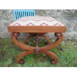 A 19th century mahogany scrolling cross frame stool, united by turned stretcher, with upholstered