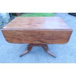 A 19th century mahogany pembroke table, raised on a turned column, with a platform base