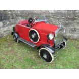 A red rotary pedal car, in the style of Rolls Royce “Brooklands” 1926, with a “Dickie” seat , 60”