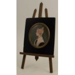 A 19th century miniature portrait of a girl, painted in profile wearing a white bonnet, with a