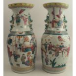 A pair of late 19th century Chinese vases, painted with a variety of figures in conversation,