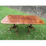 An oak extending dining table, raised on two pedestals, with an extra leaf, max. length 83.5ins,