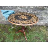 An oval occasional table, having a fern work decorated top, raised on a tripod base, max diameter