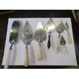 A collection of silver slices, or trowels, some engraved, some with ivory handles