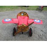 A rotary pedal red single seater plane, with solid rubber tyres, 46” long x 35” wing span