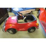 A red VW Beetle cabriolet pedal car, with swing pedals and solid rubber tyres, 34” x18”