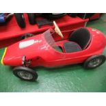 A red swing pedal racing car, with solid rubber tyres, approx. 48” x 20”