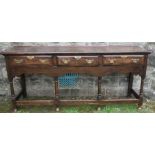 An oak dresser, fitted with three drawers above a shaped frieze, raised on four turned legs,
