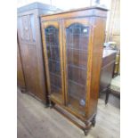 An oak glazed cabinet, with lead lined glazed doors, opening to reveal adjustable shelves