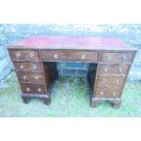 A mahogany desk, fitted with one long drawer, flanked by two short drawers over two pedestals of