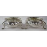 A pair of Victorian silver open salts, with embossed decoration, raised on three scroll feet, weight