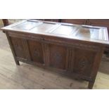 An oak coffer, with four panelled top over a four panel and carved front, 62ins x 26ins, height