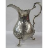 A Victorian silver jug, with engraved decoration, raised on three scroll feet, date letter rubbed,