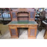 An Edwardian oak twin pedestal desk, the superstructure fitted with two cupboard doors, having