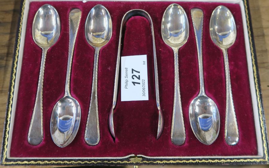 A cased set of six hallmarked silver tea spoons, together with sugar tongs, with feather edge