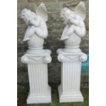 A pair of modern plastic cherubs, sleeping on urns on pedestals, height 53ins