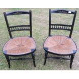 A pair of Aesthetic Movement ebonised low fireside chairs, with gilt decoration and rush seats, in