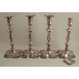 A set of four loaded silver candlesticks, with shell decoration and knopped column, London 1905,