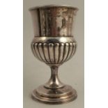 A Georgian silver pedestal cup, with gadrooned lower body, the base set with a coin, London 1810,