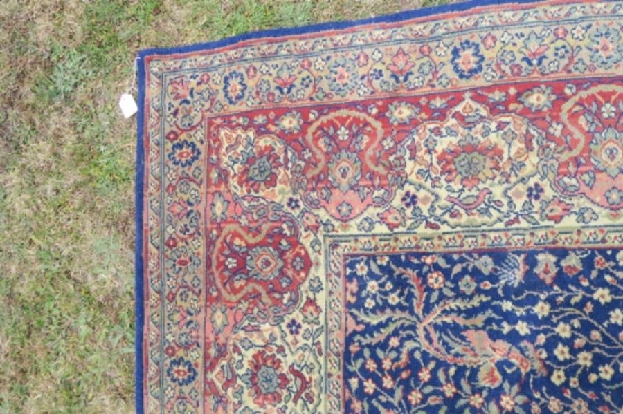 A large Eastern design rug, having a blue ground to a red border, decorated with foliage and - Image 3 of 4
