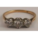 A three stone diamond ring, stamped '18c', the graduated brilliant cuts totalling approximately 0.