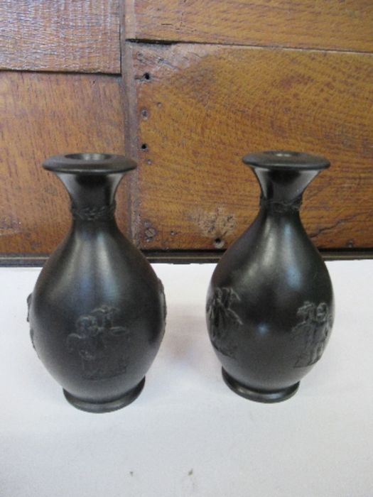 A pair of Georgian Wedgwood black basalt bud vases, each with three classical cherub motifs and - Image 2 of 4