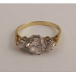 A three stone diamond ring, in an 18ct gold mount, the principal old brilliant cut measurers