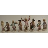 A Continental porcelain nine piece monkey band, comprising conductor and eight playing musical