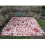 An embroidered bed spread, with red foliate decoration, 101ins x 101ins