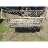 A metal folding crib, with rope work sides, on casters