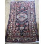 An Eastern design rug, predominately decorated in red ad blue, 69ins x 40ins