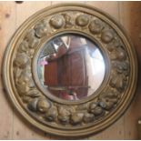 A circular gilt framed wall mirror, the frame decorated with fruit, overall diameter 24ins