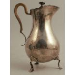 A silver covered jug, of baluster form, with shaped edge and wicker insulated handle, raised on