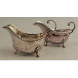 A silver sauce boat, with gadrooned edge, scroll handle and raised on three scroll legs with pad