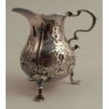 A Georgian silver jug, of baluster form with embossed decoration, raised on three scroll legs and