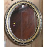 A 19th century Irish oval wall mirror, the frame decorated with bands of black and gold with faux