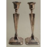 A pair of hallmarked silver candlesticks, on square bases, af and repaired, height 10.5ins