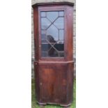 A 19th century mahogany free standing double corner cupboard, the upper section having astragal