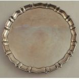 A silver salver, with ogee border, raised on three knurl feet, London 1936, weight 12oz, diameter