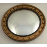 A Regency style circular convex gilt framed mirror, max diameter 24ins