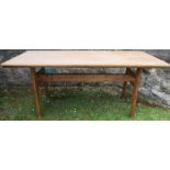 A pine kitchen table, raised on end supports united by a stretcher, 62.5ins x 26.5ins, height 28ins
