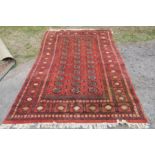 An Eastern design orange ground rug, decorated with stylised geometric medallions, 105ins x 74ins