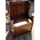 An oak boxed seat, with carved decoration and hinged seat, height 36ins x width 24ins x depth 16.