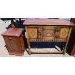 A reproduction oak side cabinet, fitted with a cupboard, having carved decoration, 36ins x 13ins x