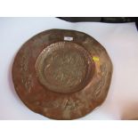 An Arts and Crafts circular copper wall plate, decorated with flowers, diameter 15ins