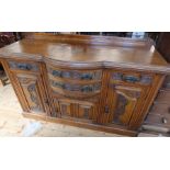 An Edwardian oak sideboard, fitted with drawers and cupboards, having carved decoration, width 60.