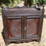 A small oak smoker's cabinet, with carved decoration, fitted with a pair of cupboard doors, 18.