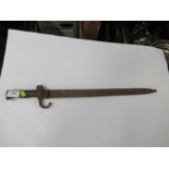 A bayonet with metal scabbard, fullered blade and stud work to the wooden handle